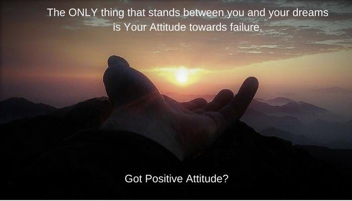 A hand reaching toward a sunrise over mountains — your attitude toward failure is the only thing between you and your dreams.